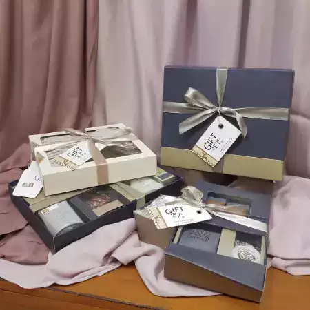 Presentation gift boxes containing assorted chocolate bars and truffles with tasting guide cards for corporate and personal gifting